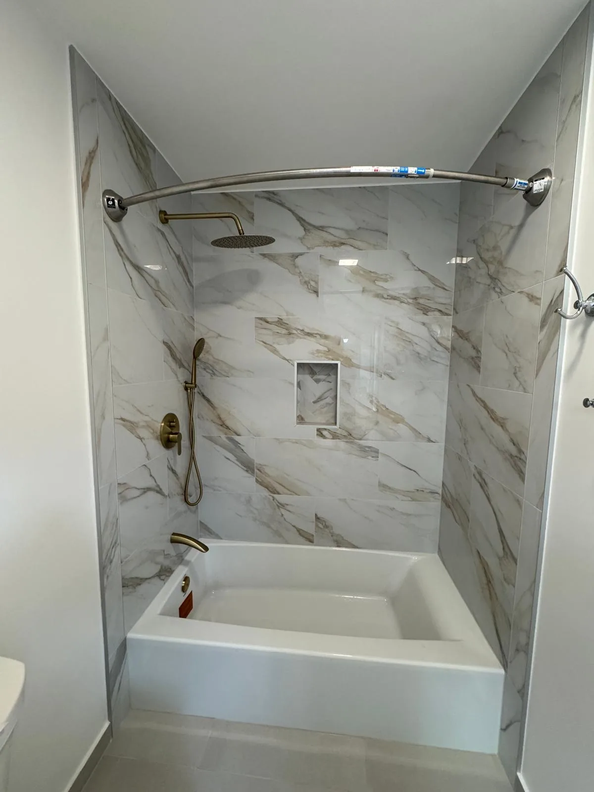 White marble shower walls with pebble stone floor